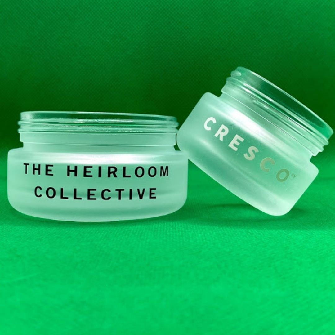 two frosted glass bottles with a green background