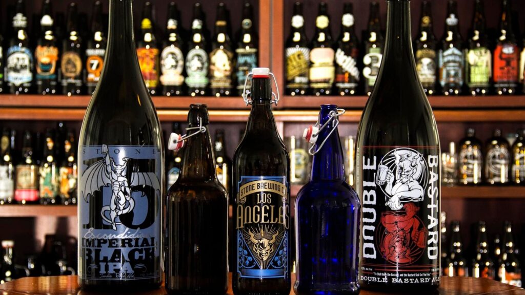 different beer bottles lined on a bar