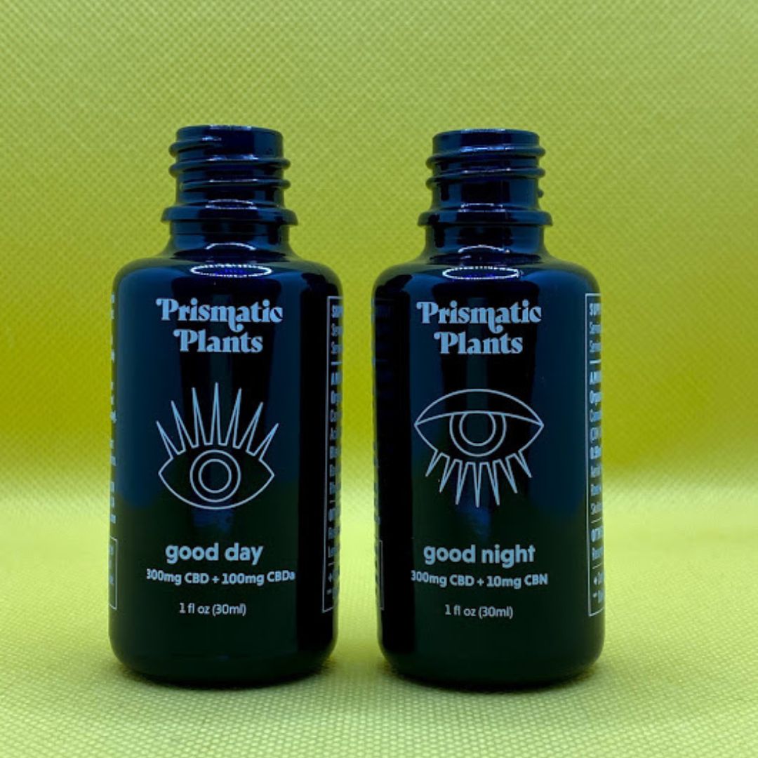 two CBD bottles on a green background